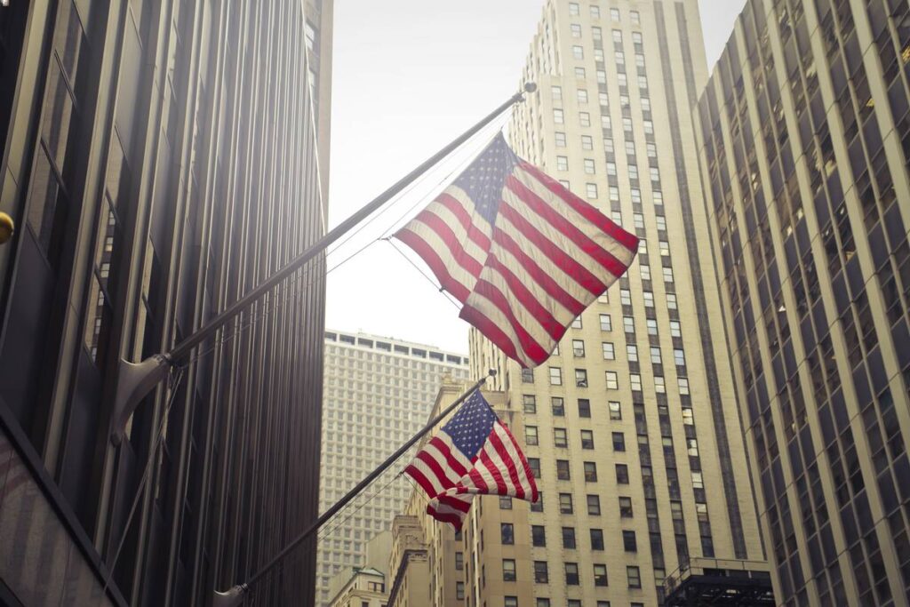 Manhattan scrycrapers and US flag indicating the NYC job market