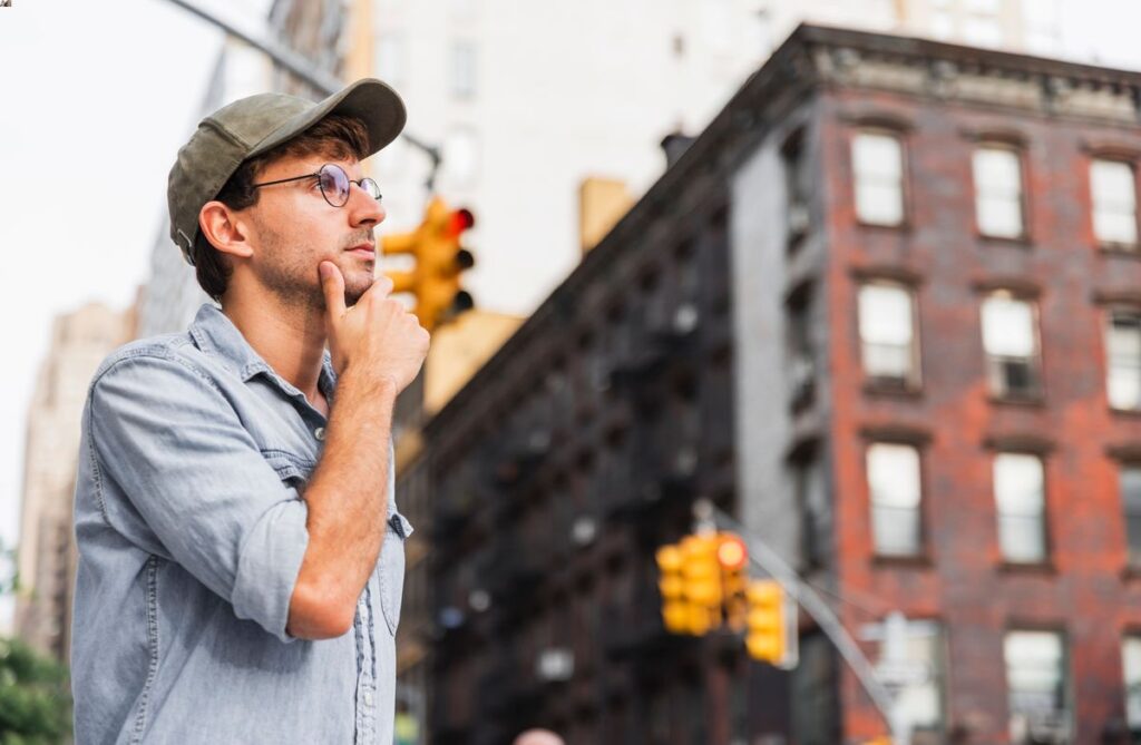Thinking man with glasses on a street in NYC