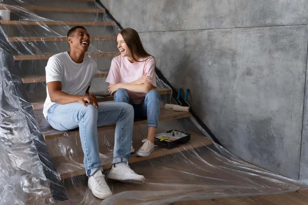 Couple sitting on stairs, after water damage remediation in New York
